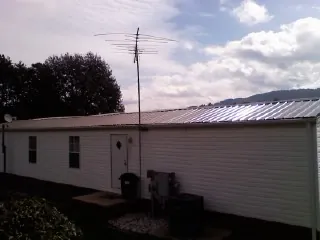New metal roof on a single wide mobile home with a TV antenna in Fredonia